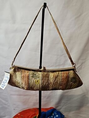 Vintage-style 1950s floral brocade handbag features a metallic clasp.
